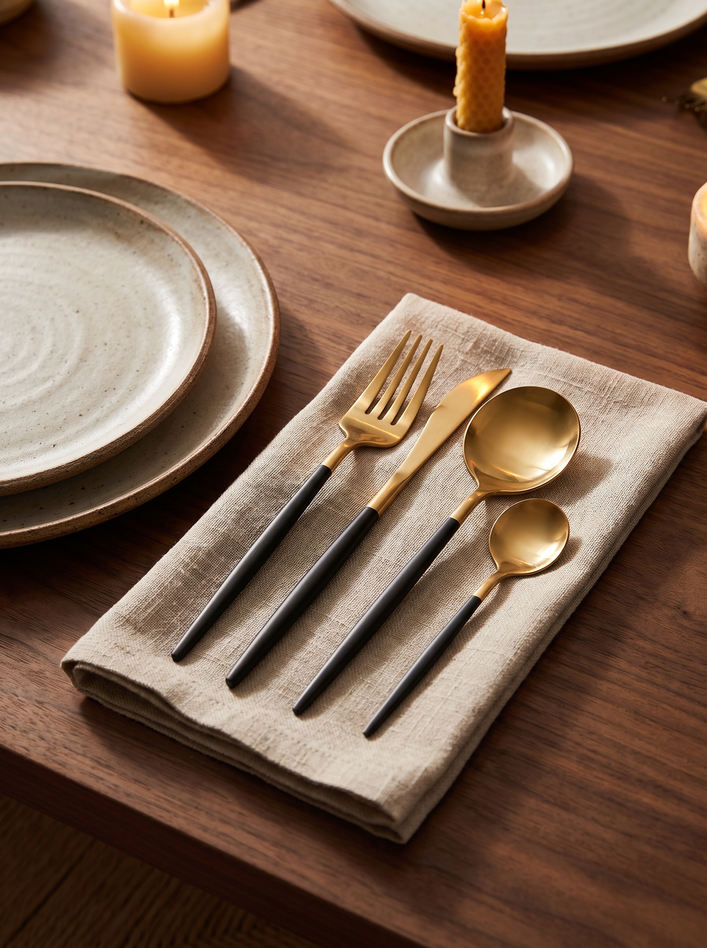 Black and gold cutlery on walnut table